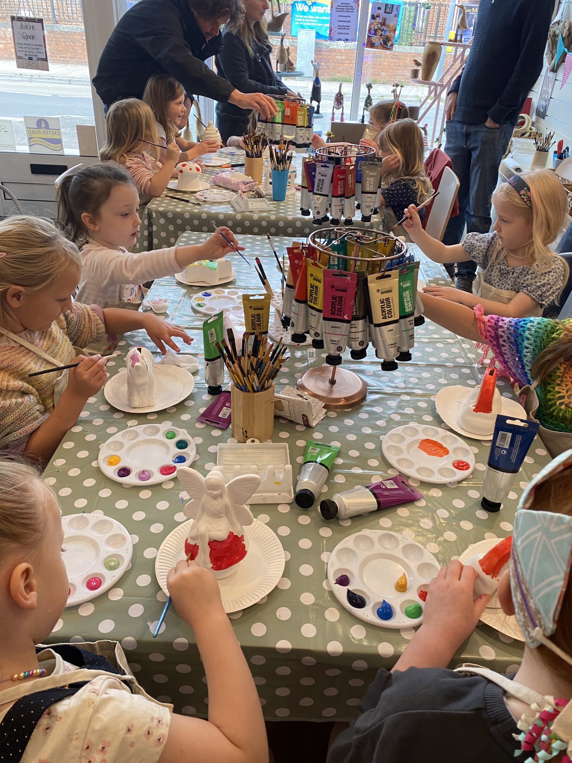 childrens party at arty boat, group of children sat around a table painting