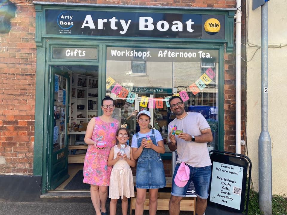 family outside arty boat exmouth, showing their painted pottery 