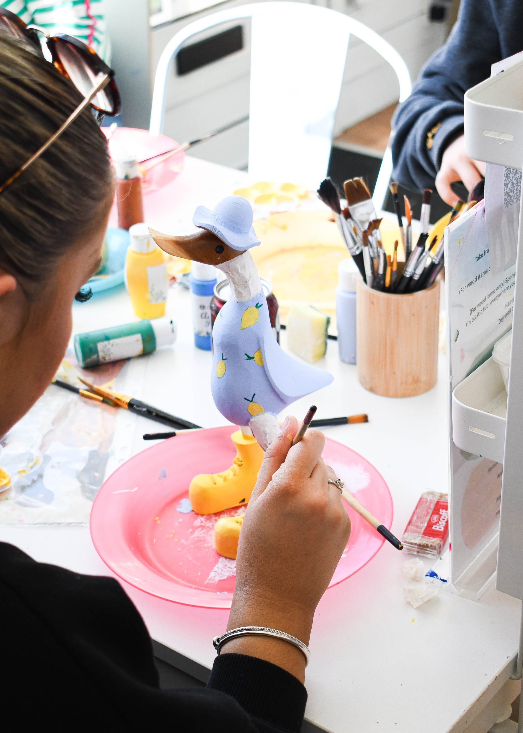 Visitors enjoying an indoor pottery and wood painting session at Arty Boat Exmouth