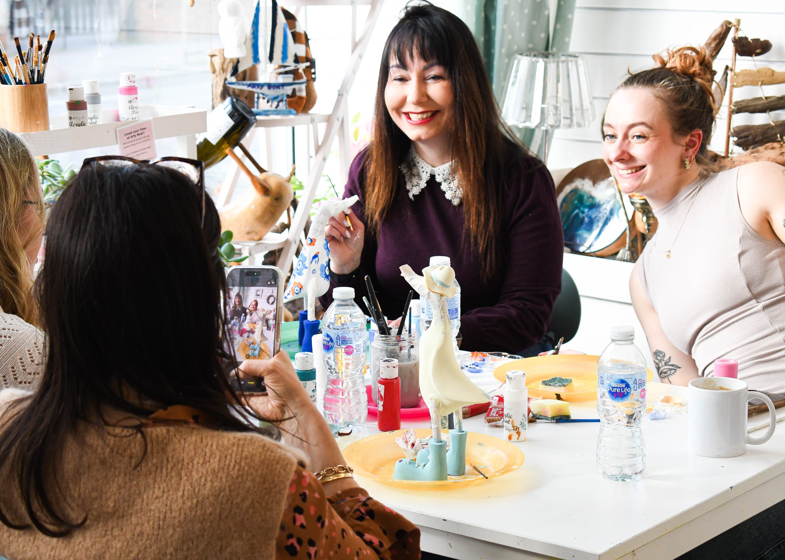 Adults enjoying pottery and wood painting at Arty Boat in Devon